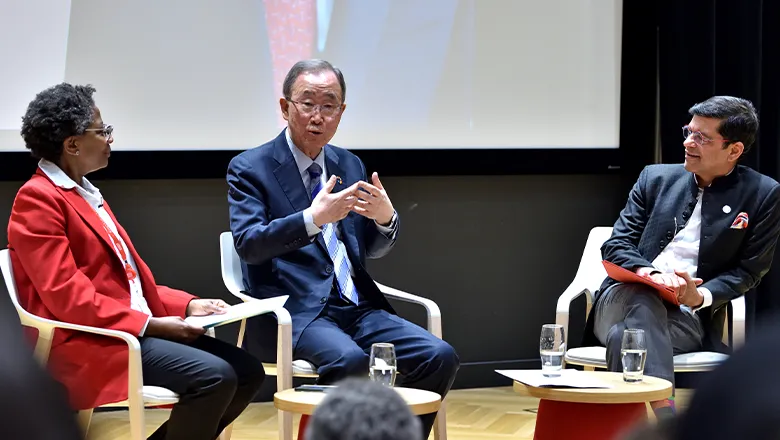 Ban Ki-moon speaking on stage with Professor 'Funmi Olonisakin and Professor Shitij Kapur on 1 May 2024