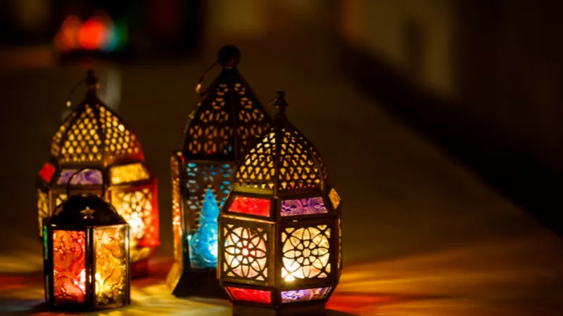 Four lit Ramadan lanterns of different sizes and colours.