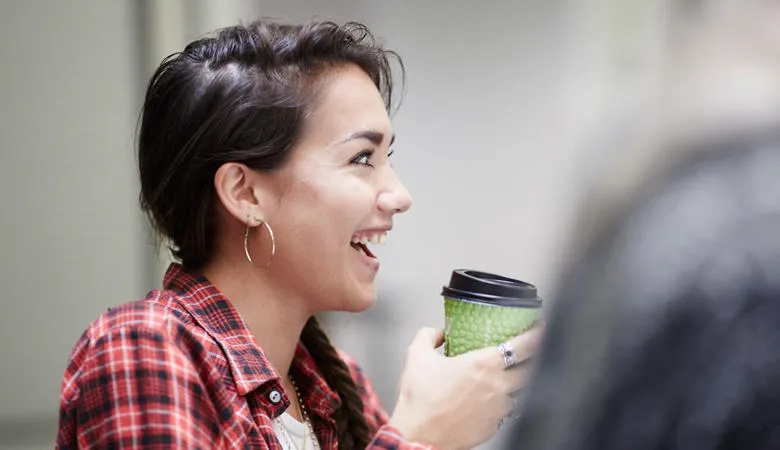 A student holding a coffee cup