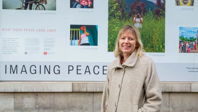 Dr Tiffany Fairey standing by outdoor exhibition of Imaging Peace Photo Credit Jack Latimer