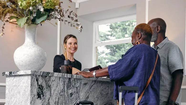 Hotel receptionist greets guests