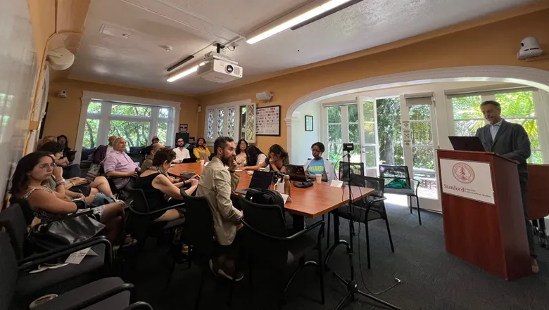 Professor Octavio Ferraz giving a lecture in Stanford