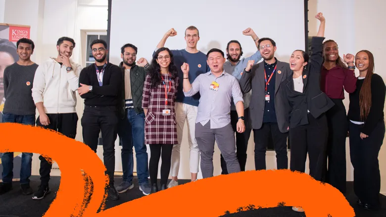 12 people standing on stage cheering