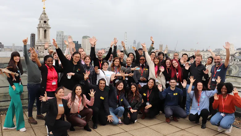 Group of people cheering for the camera on roof top