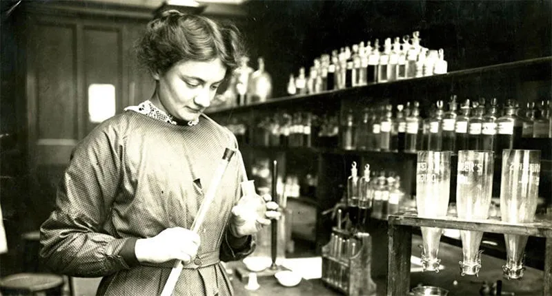 An archival photograph of a woman working in a laboratory.