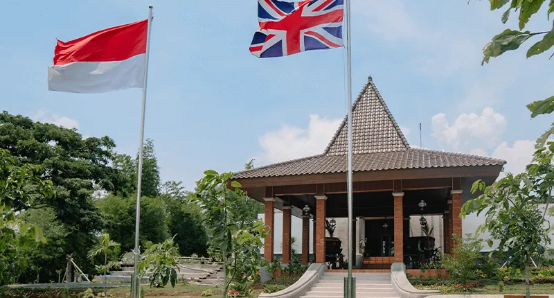 Exterior of a building in the Singhasari Special Economic Zone, behind the flag of Indonesia and flag of the United Kingdom.