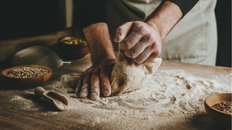 Hands kneading dough. Image: Adobe Stock.