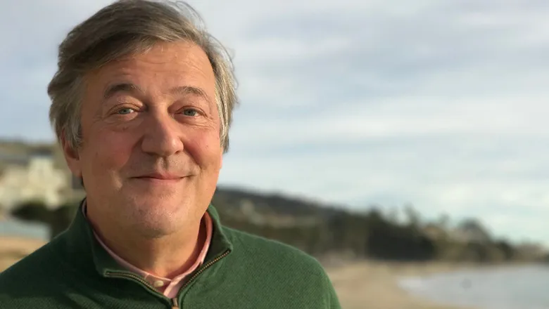 Stephen Fry smiling in front of the camera.