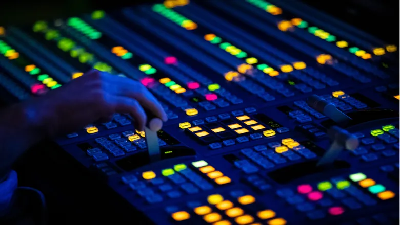 Close up of a video control switcher board with brightly coloured lights. Shutterstock