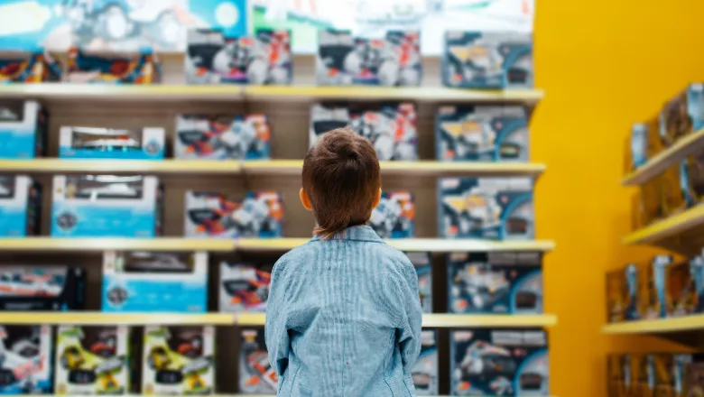 Boy looking at the shelves in a toy store.