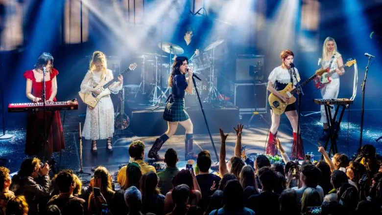 Band performing on stage in front of audience.