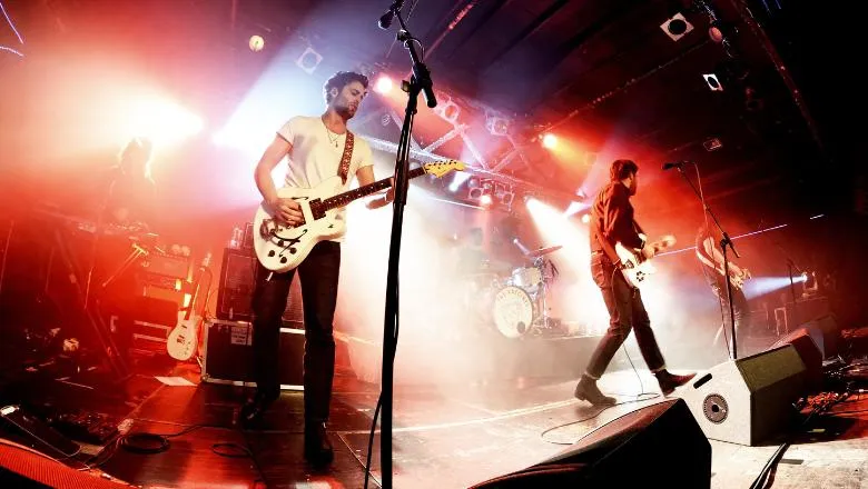 Band on stage in front of red lighting.