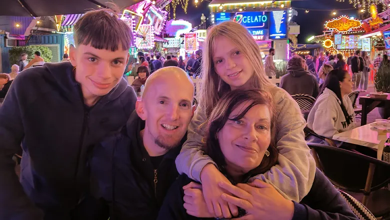 A mother and father sit with their two children during a holiday trip