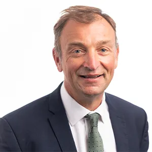 A man wearing a blue suit jacket, white shirt and light green tie