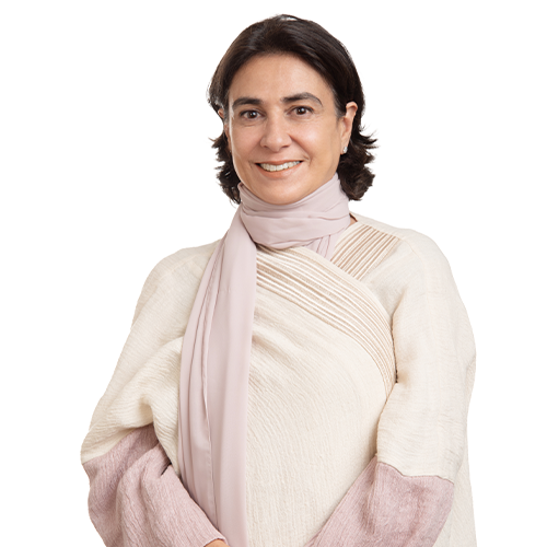 A woman with brown hair wears a light pink scarf and white top