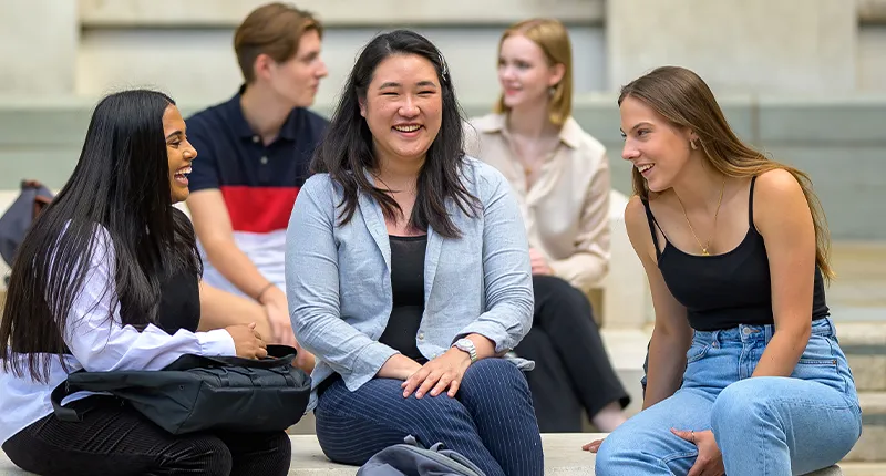 Three students sit and laugh