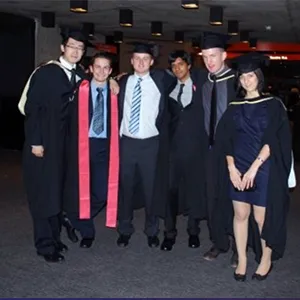 A group of six people wearing graduation robes in a relaxed pose