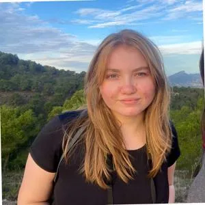 Amy's headshot against a mountainous landscape.