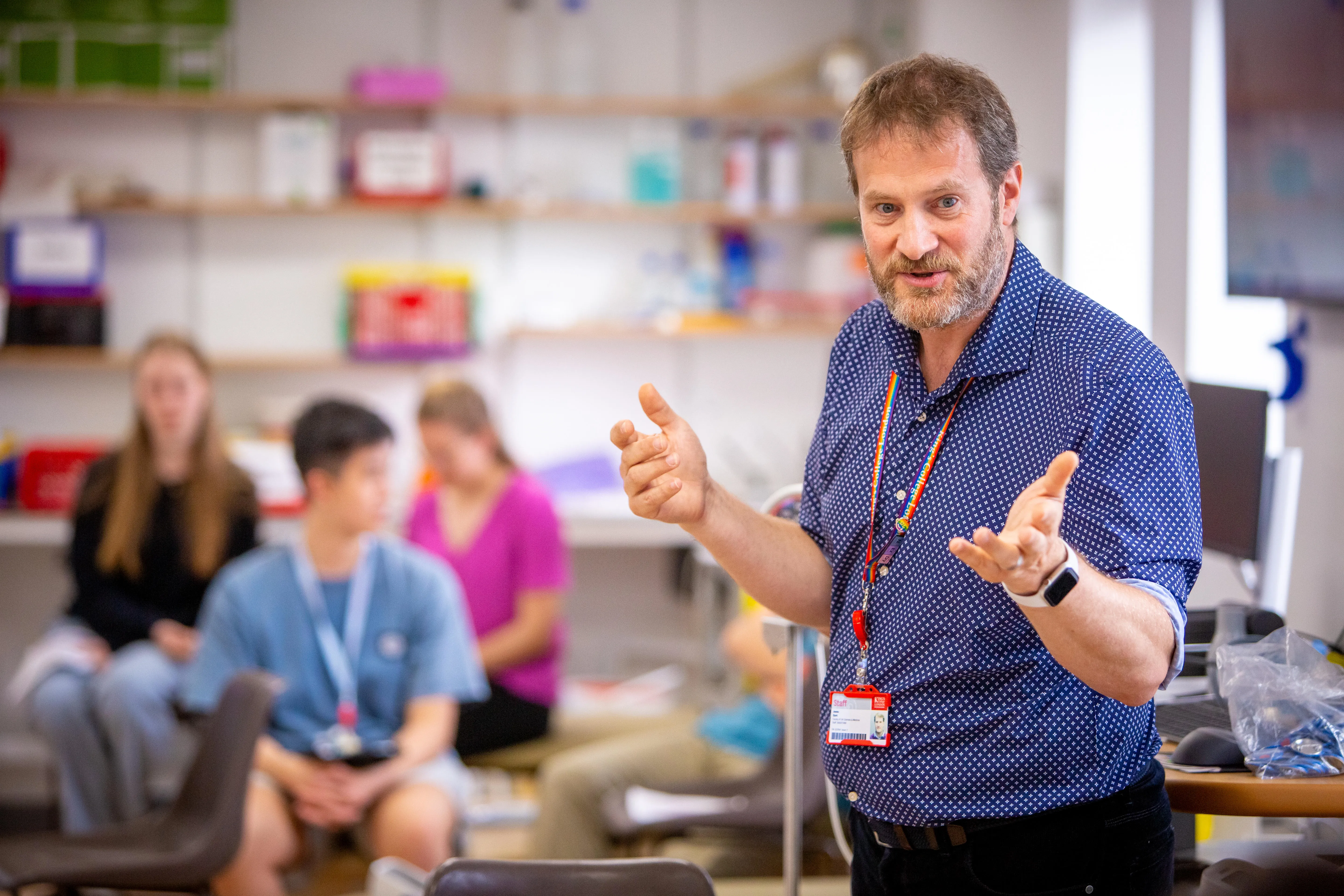 A staff member talking to a group of students at a King's summer school.