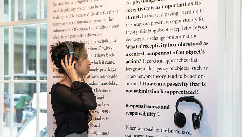 A person wearing headphones looking at a display with text on