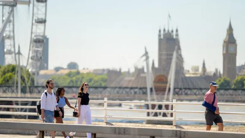 Three international students walking across Waterloo Bridge together.