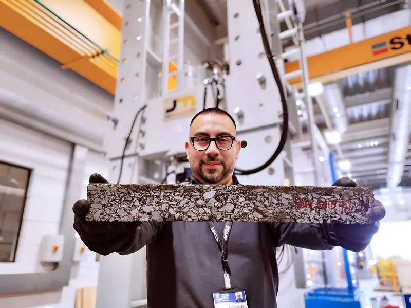 Researcher holds up a sample of road material