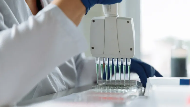 Researcher in the laboratory using a pipette.