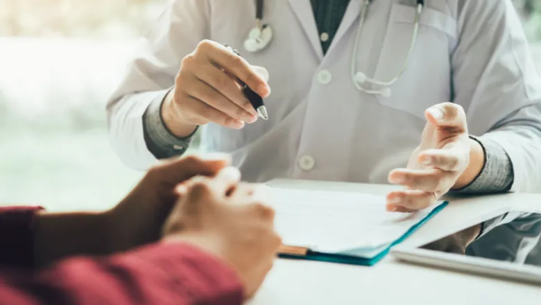 Doctor speaking with patient and going through paperwork.