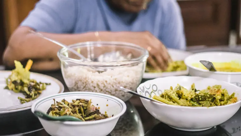 Someone sitting down at a table eating a meal