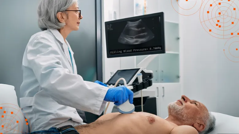 Female clinician performing an echocardiography exam on a senior male, who is lying down on a hospital bed.