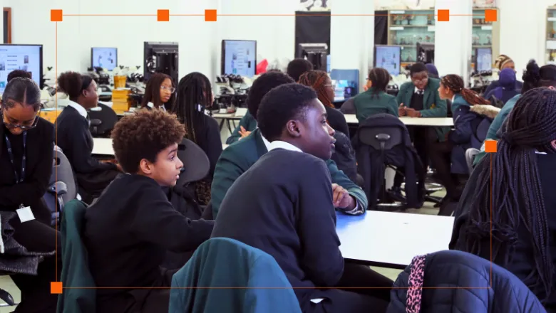 Two Black school pupils overlook a scene in a science classroom.