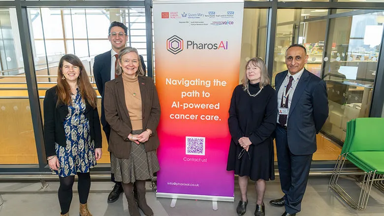 A group of people stand either side of a poster for PharosAI