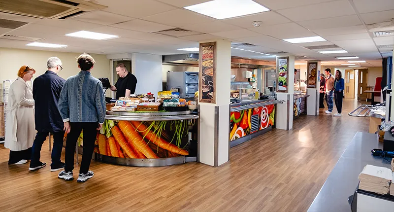 People queuing for food in a canteen