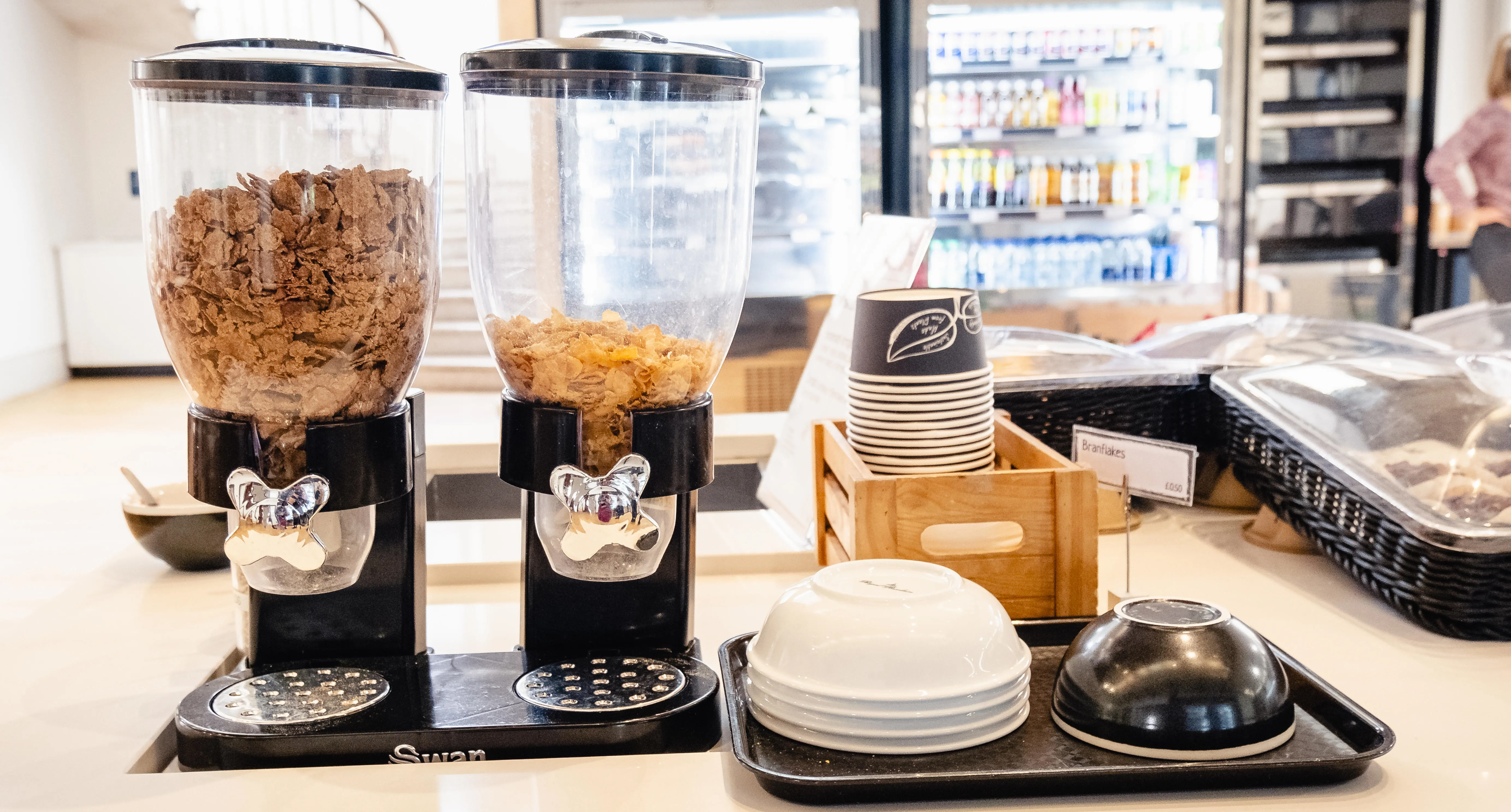 A table with cereal dispensers and bowls