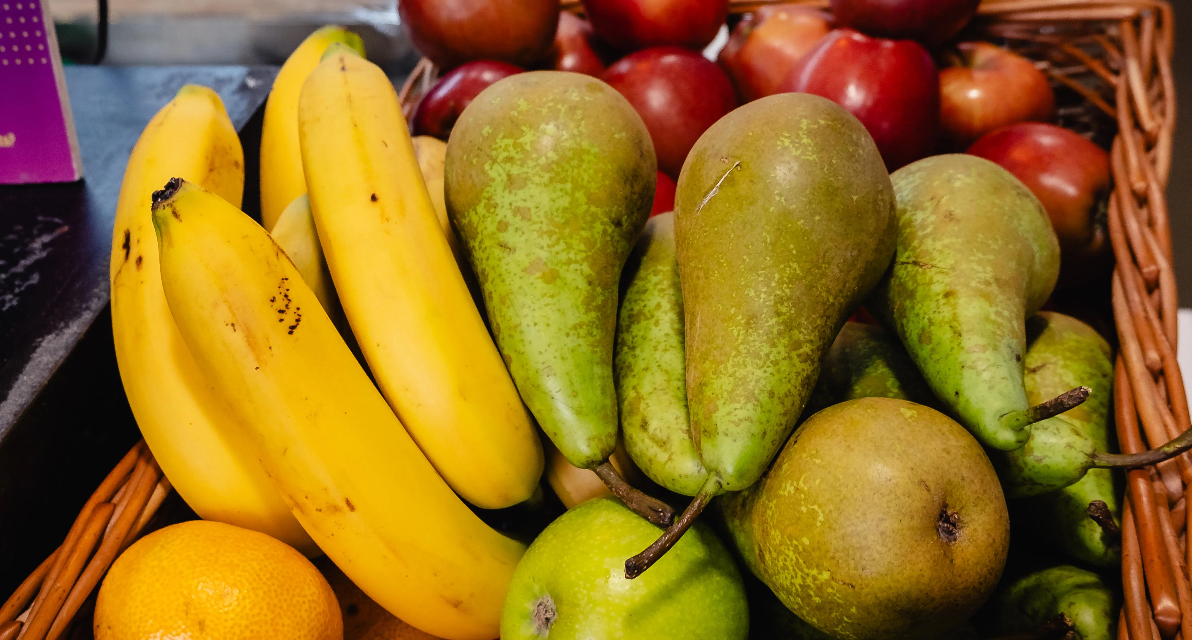 A basket of bananas, pears and apples