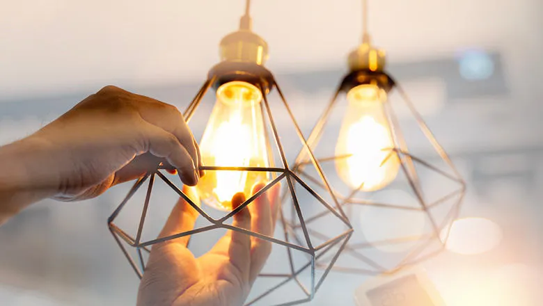 Hands changing a lightbulb