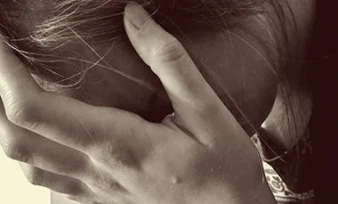 A woman holding her head in her hands.