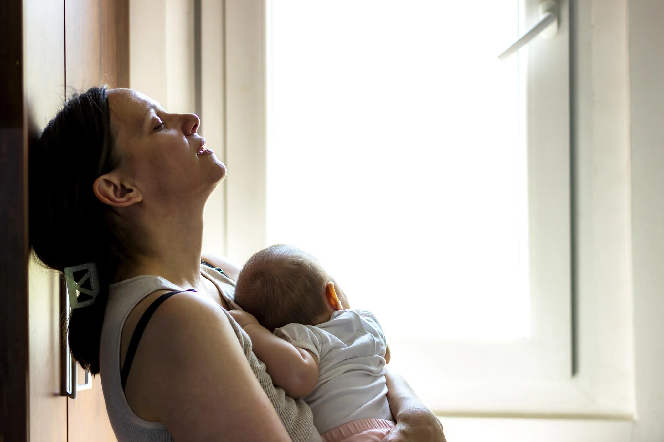 Woman looking distressed holding a small baby