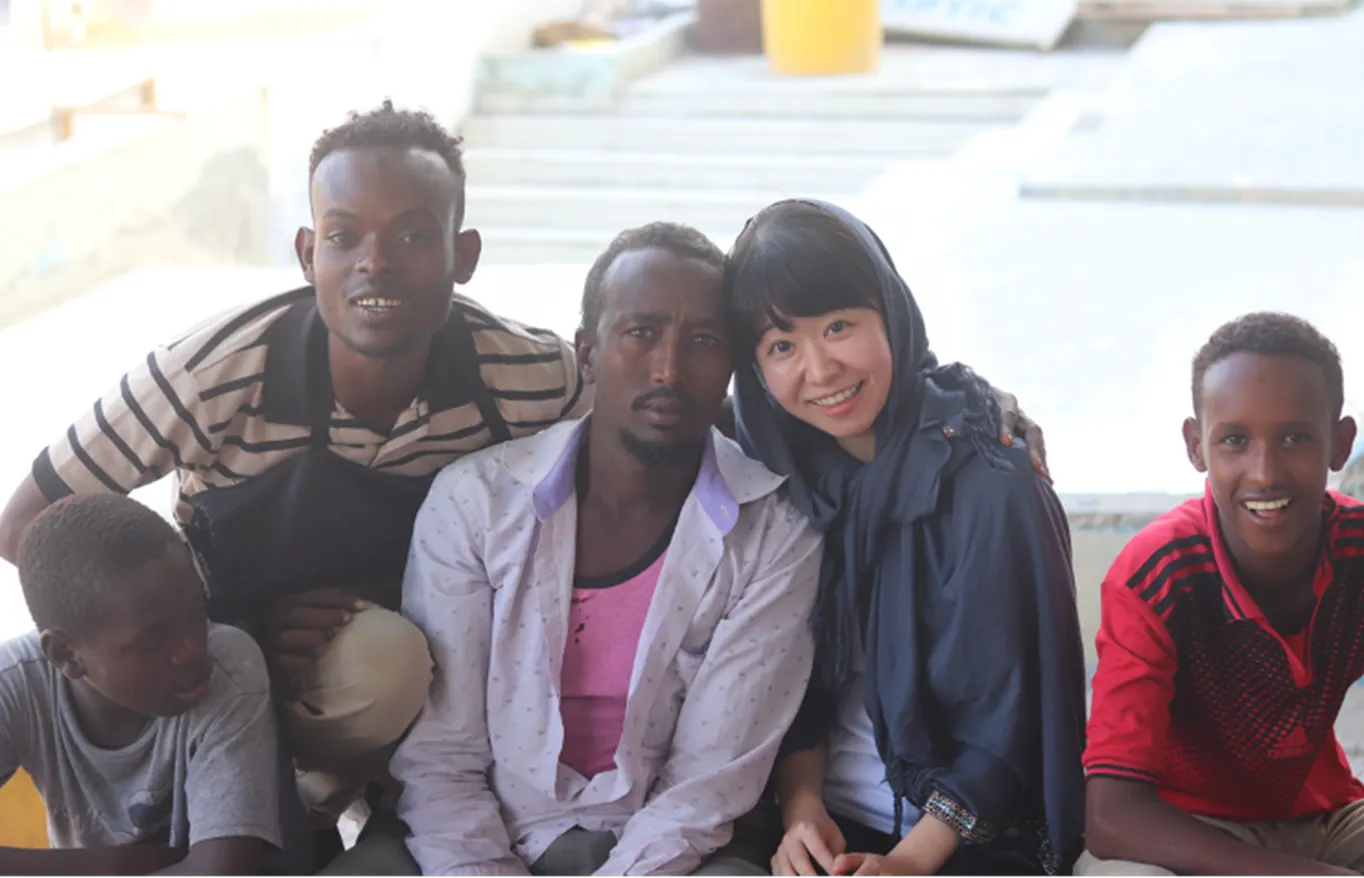 A group of five people seated in a row and similing