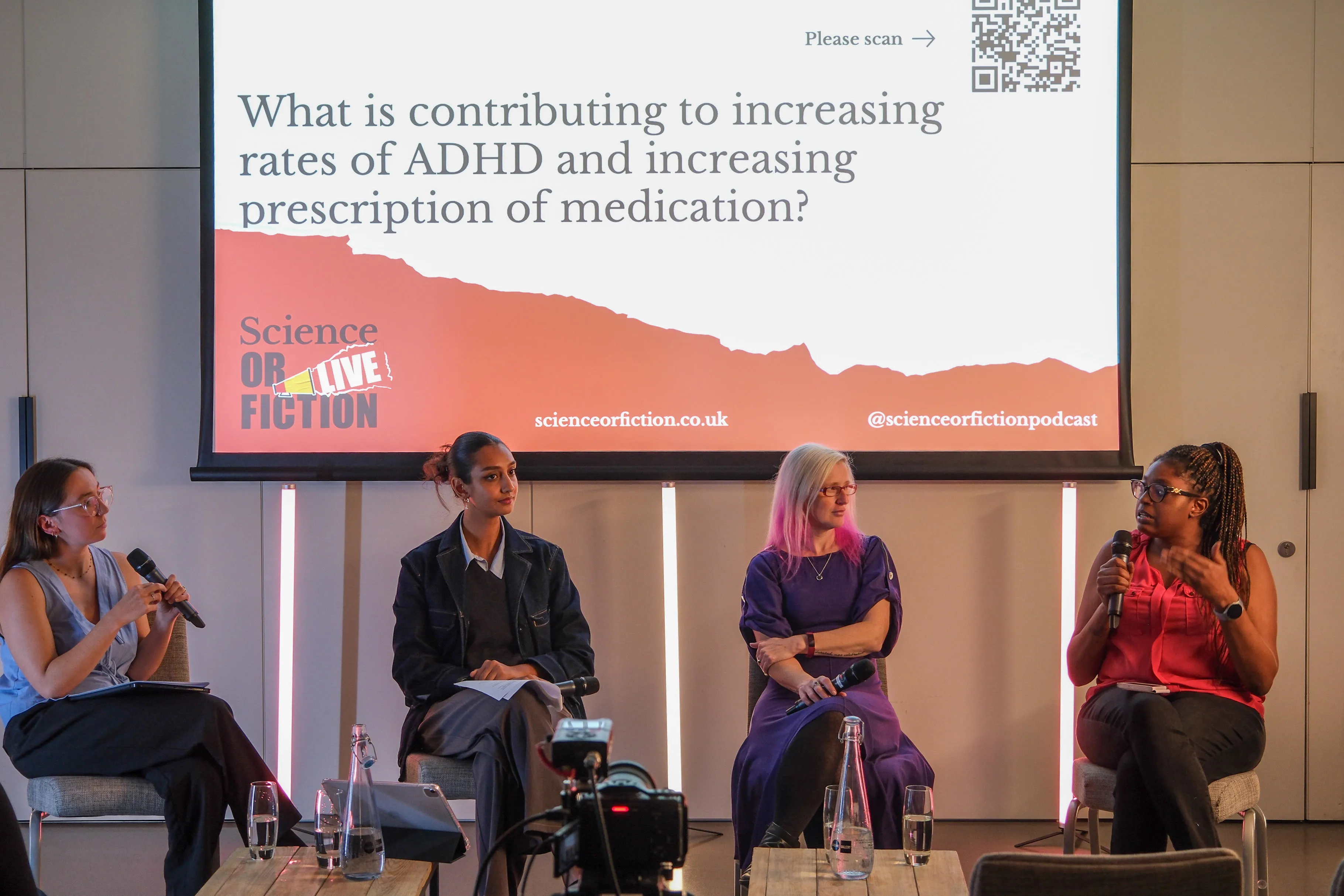 Four panelists seated in front of Science or Fiction Podcast slide on screen