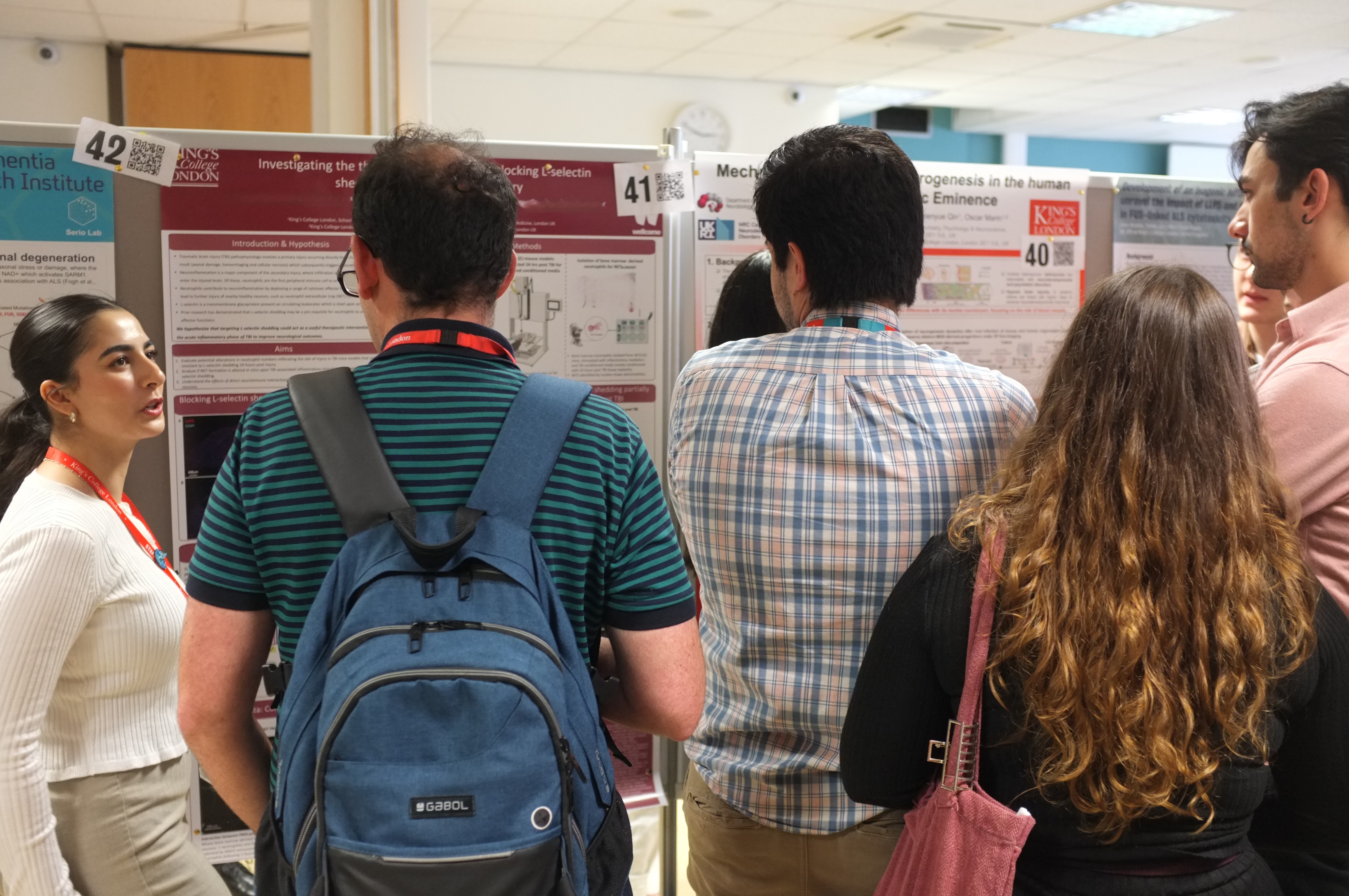 PhD student presenting their work in poster format to attendees