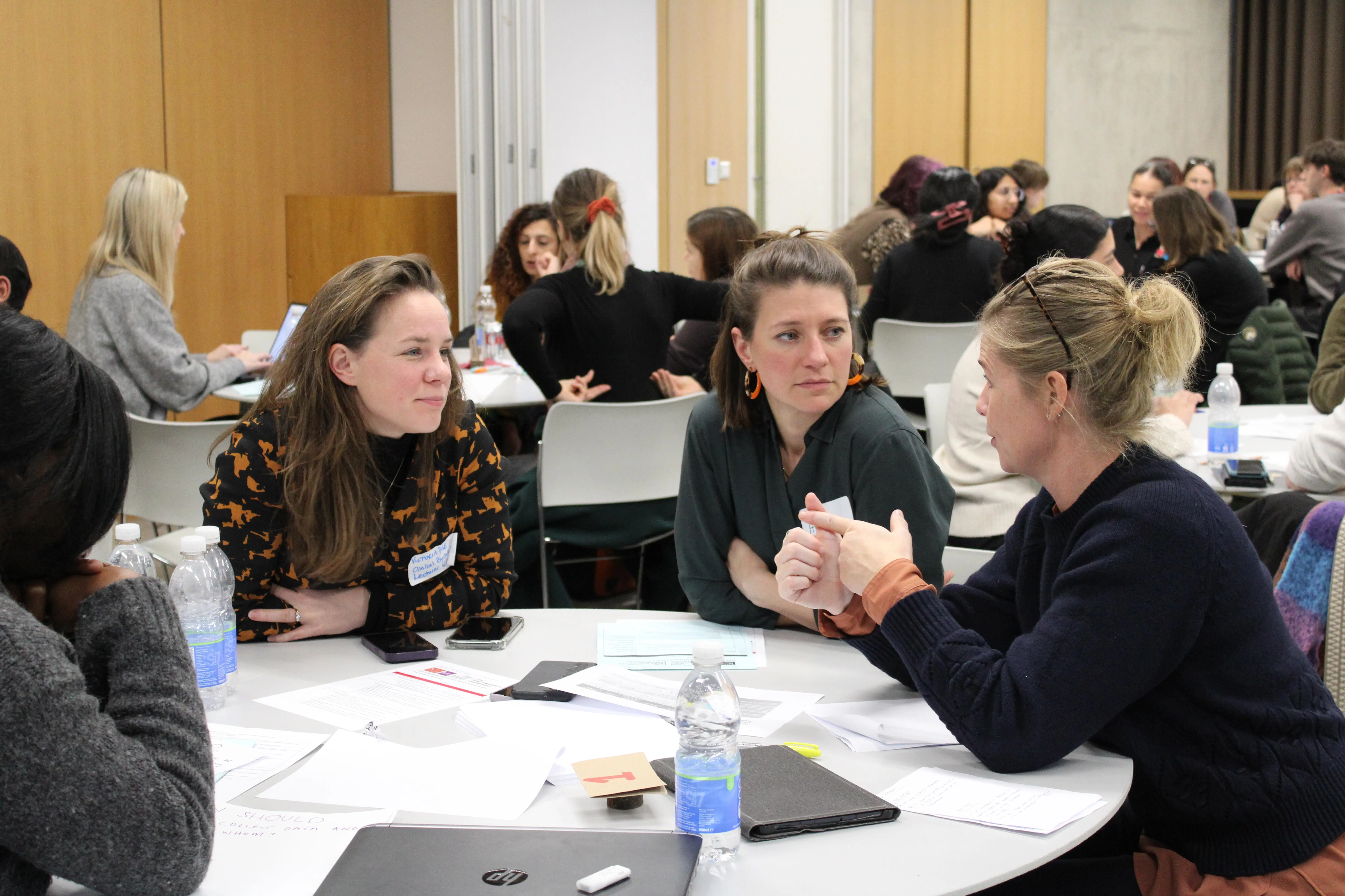 Three people in discussion around a table at the School Mental Health Innovations Network Launch