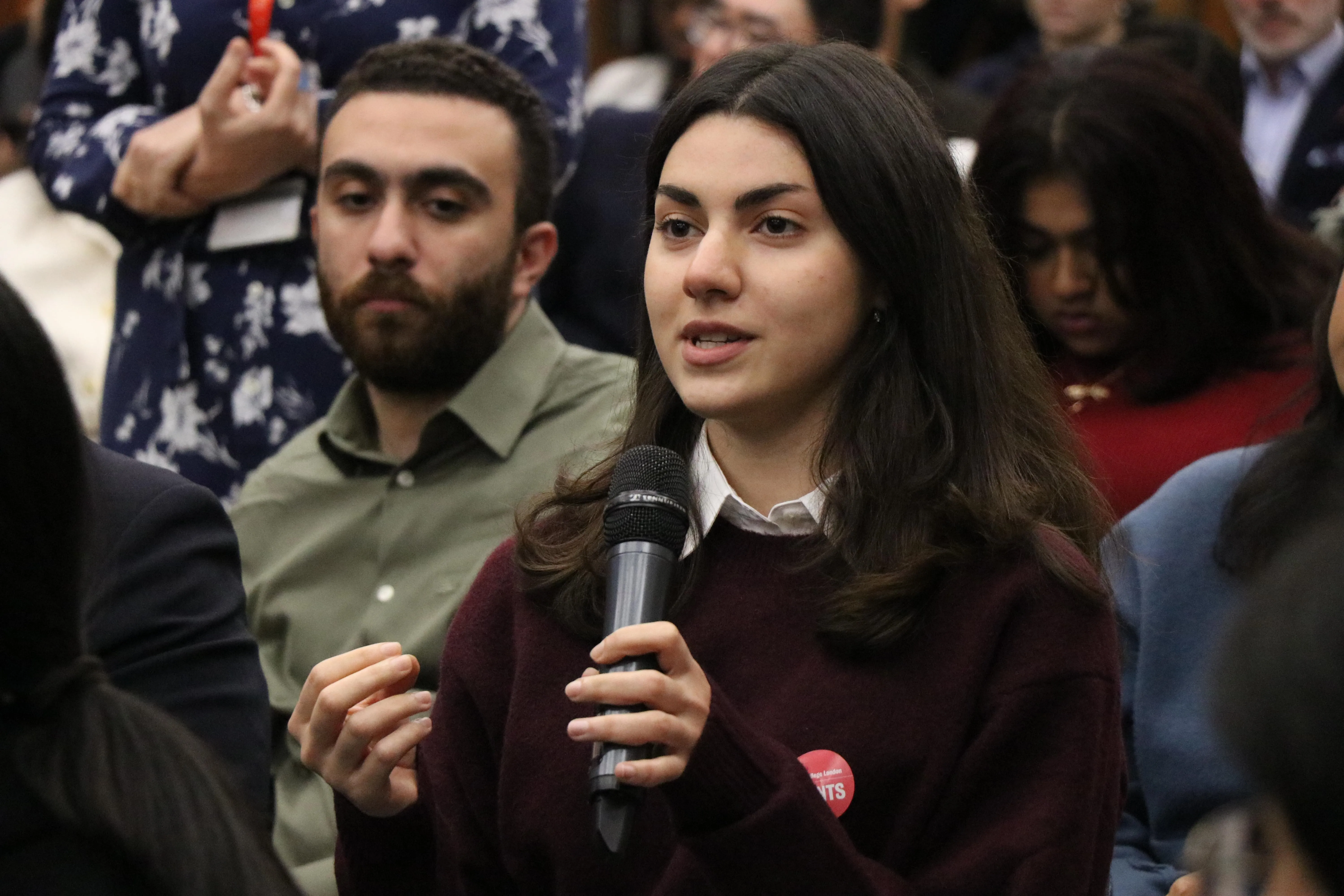 Woman asking a question in an audience