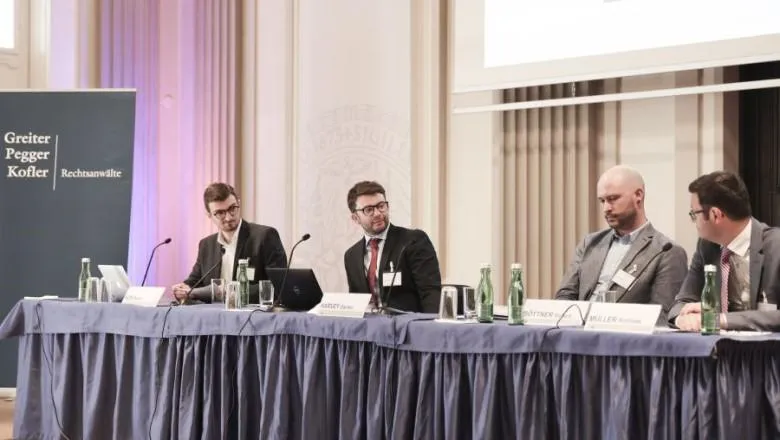 A group of men are sitting on a panel 