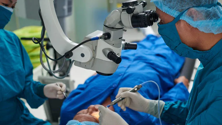 A surgeon performs surgery with the assistance of a camera.