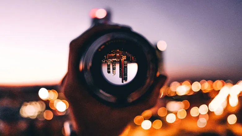 shallow focus photography of person holding camera lens