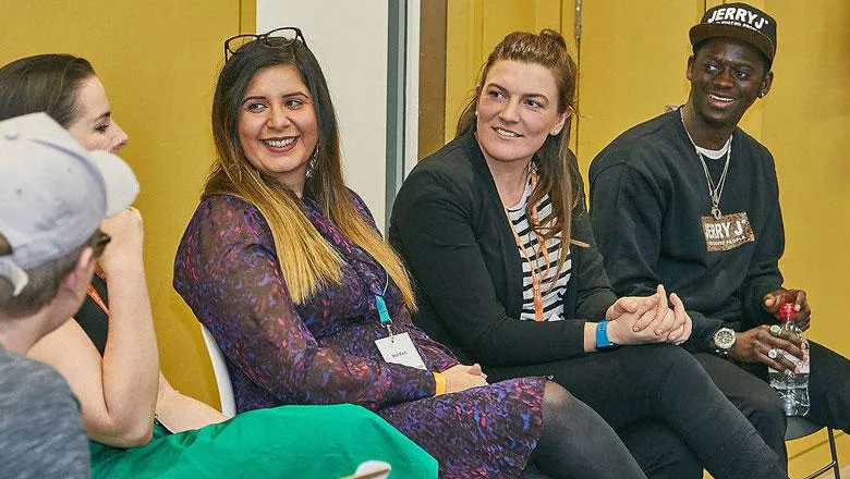 Three people smile at the speaker, obscured from camera