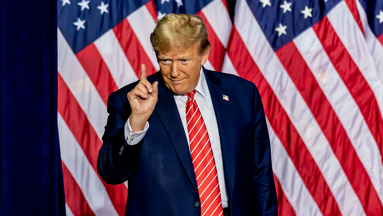 Trump pointing his finger in front of the US flag