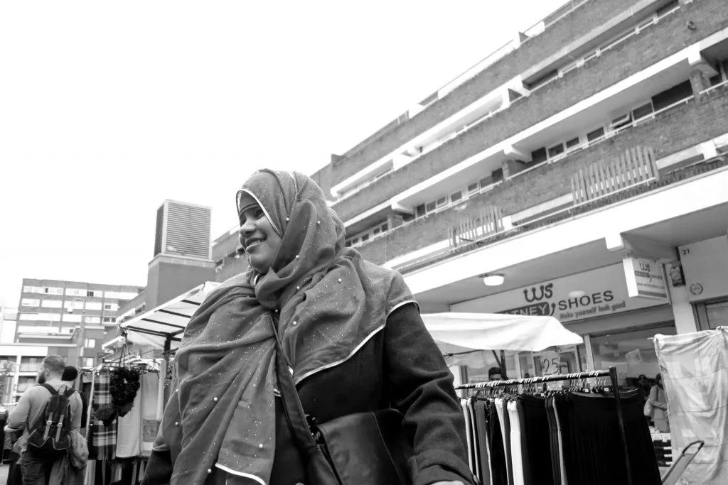 Black and white portrait of a woman smiling and wearing a veil in Watney Market