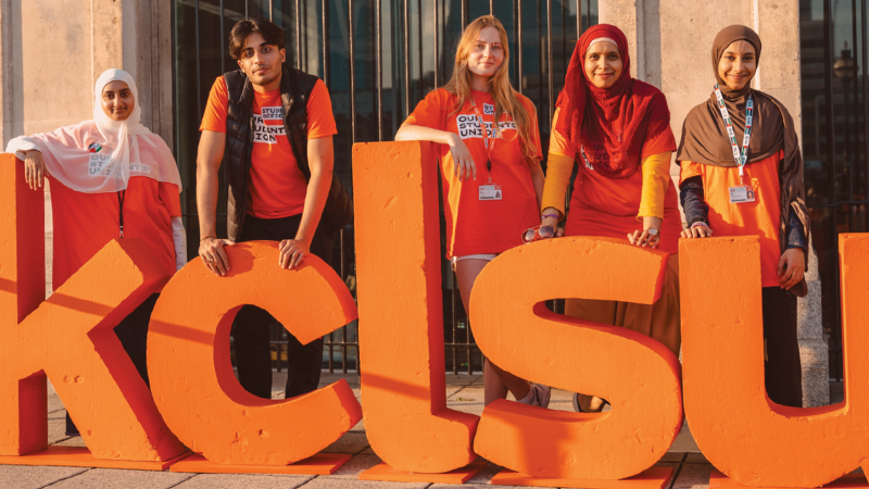 The KCLSU student officers standing behind a KCLSU sign.